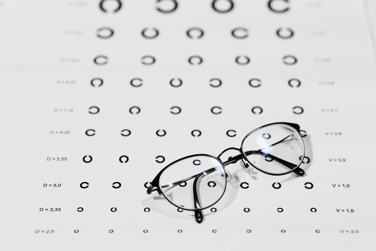 hero-img-02 Eyeglasses on a vision test chart, emphasizing eye care and optometry.